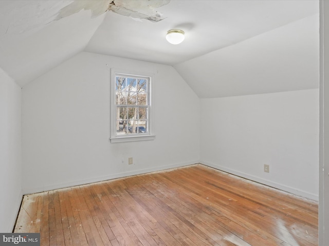 additional living space featuring lofted ceiling, baseboards, and wood finished floors