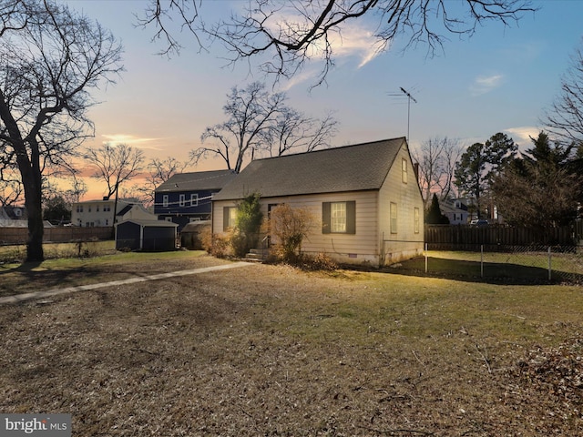 view of front facade featuring a front yard, crawl space, and fence