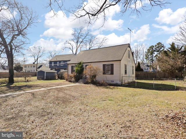 view of front of property featuring a shingled roof, crawl space, fence, and a front lawn