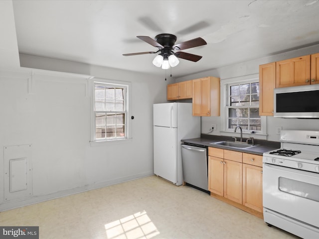 kitchen featuring stainless steel appliances, dark countertops, a sink, and light floors