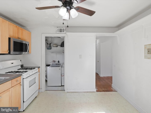 kitchen with gas range gas stove, light floors, dark countertops, visible vents, and stainless steel microwave