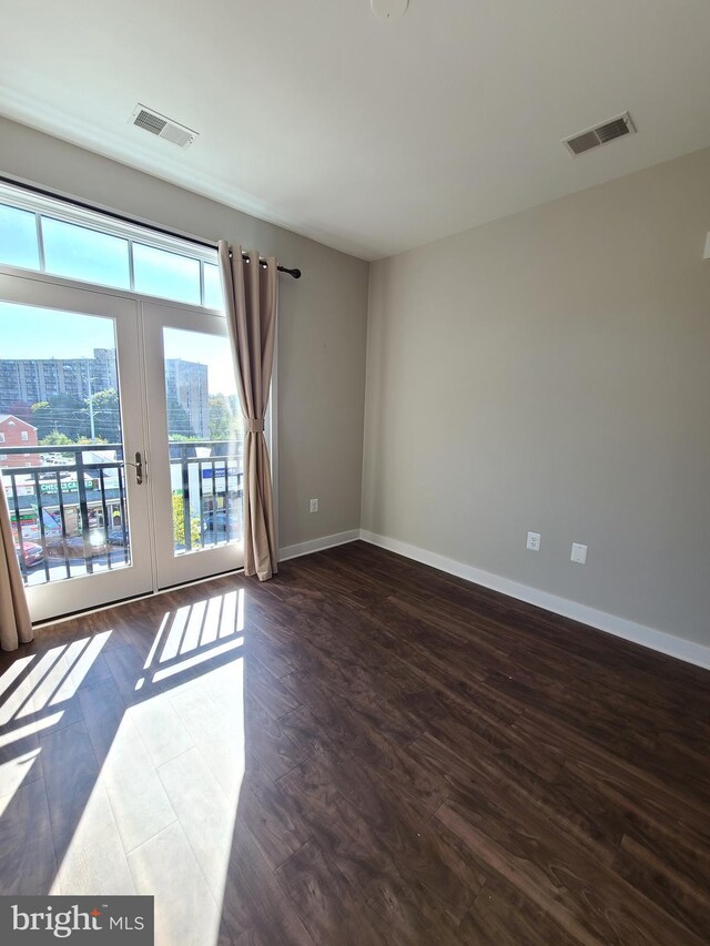 989 S Buchanan St Unit 320, Arlington, VA 22204 - empty room featuring dark wood-type flooring, a view of city, visible vents, and baseboards