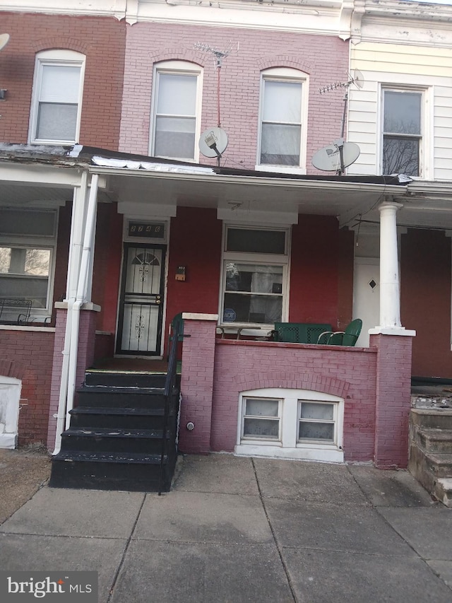 view of front facade with covered porch and brick siding