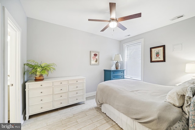 bedroom with light wood-style floors, baseboards, visible vents, and a ceiling fan