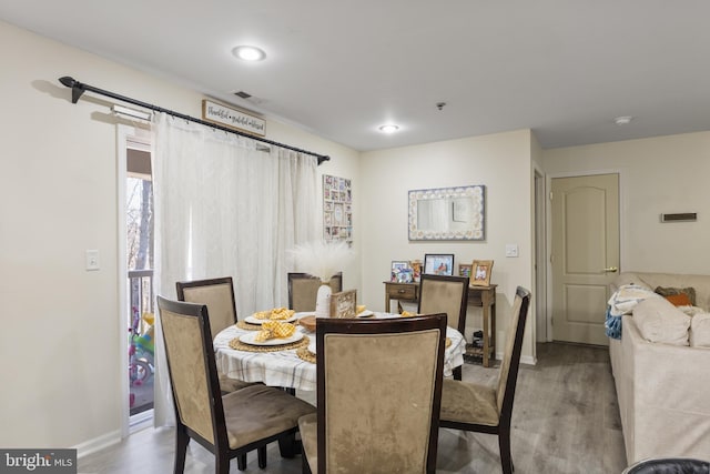 dining area featuring dark wood-style flooring, visible vents, and baseboards