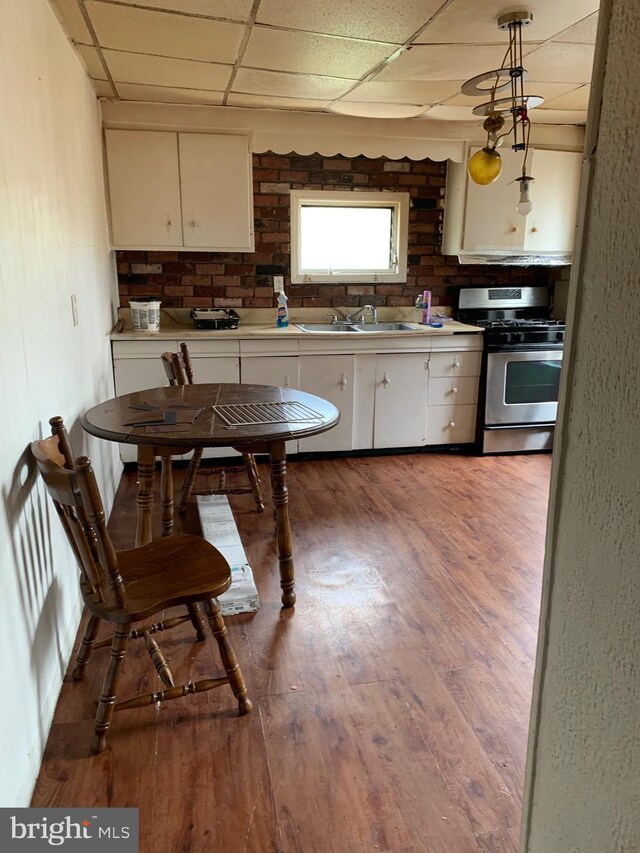 332 Elmer, Trenton, NJ 08611 - kitchen with stainless steel range with gas stovetop, a drop ceiling, white cabinets, wood finished floors, and light countertops