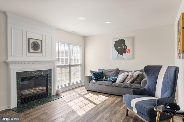 living area with a fireplace, wood finished floors, and recessed lighting