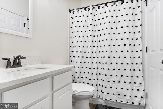 bathroom with toilet, a shower with shower curtain, and vanity