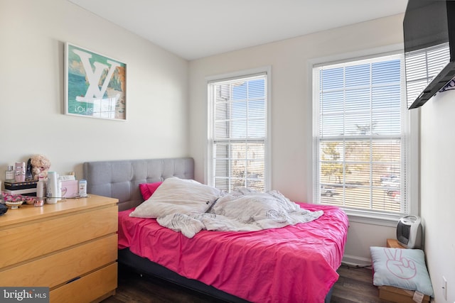 bedroom with dark wood-style flooring and baseboards