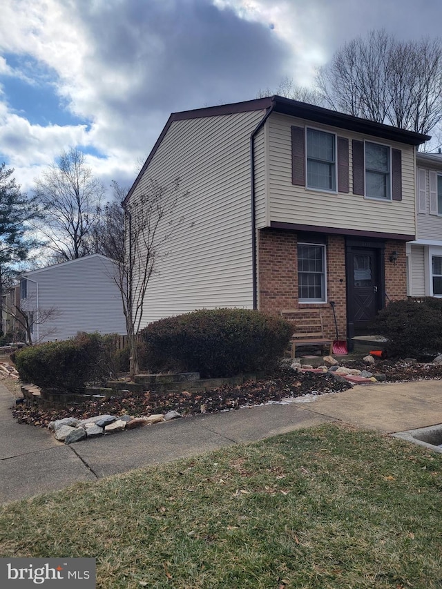 exterior space featuring a front lawn and brick siding