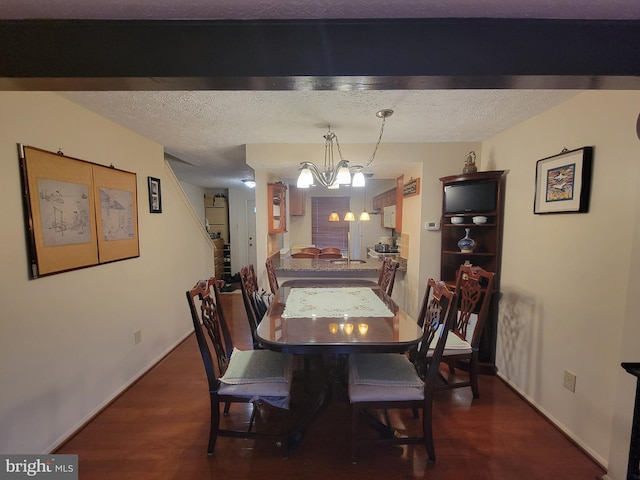 dining room featuring baseboards, a chandelier, dark wood-type flooring, and a textured ceiling