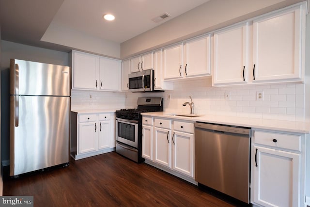 kitchen with visible vents, stainless steel appliances, light countertops, white cabinetry, and a sink