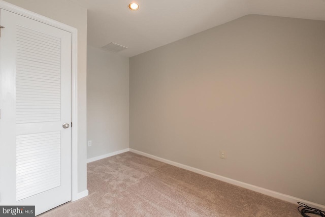 unfurnished bedroom featuring light carpet, vaulted ceiling, recessed lighting, and baseboards