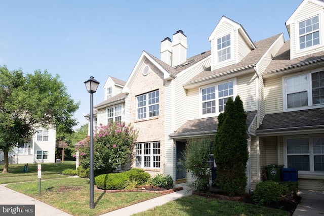 view of front of house featuring a front yard and roof with shingles