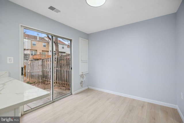 unfurnished room featuring baseboards, visible vents, and light wood finished floors