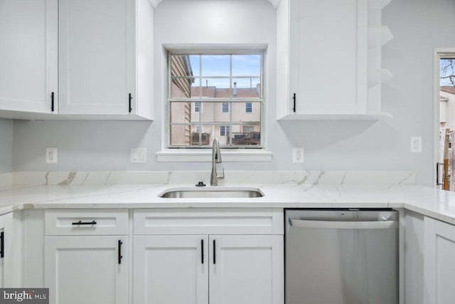 kitchen featuring light stone countertops, stainless steel dishwasher, white cabinetry, open shelves, and a sink