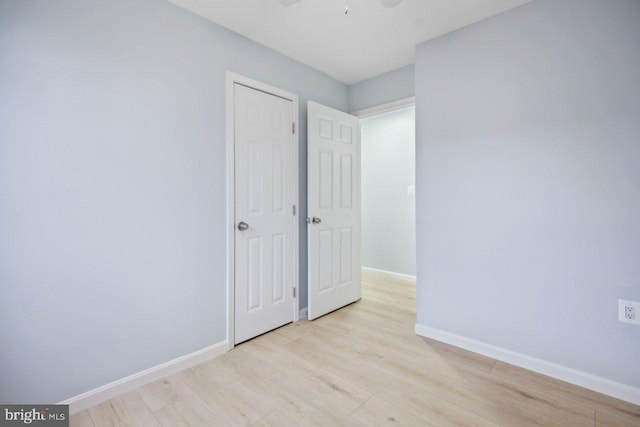 interior space with ceiling fan, light wood finished floors, and baseboards