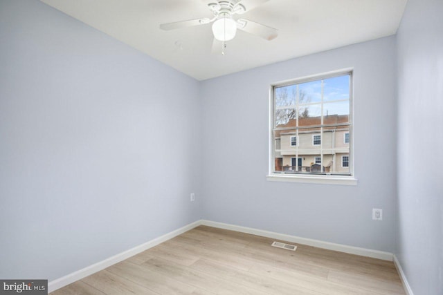 empty room featuring light wood-type flooring, baseboards, visible vents, and a ceiling fan