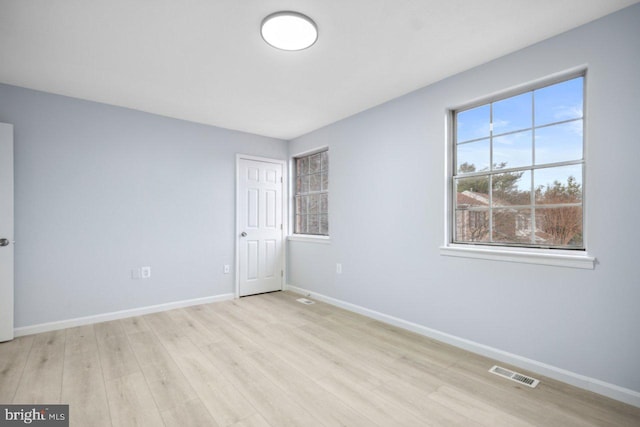 unfurnished bedroom with wood finished floors, visible vents, and baseboards