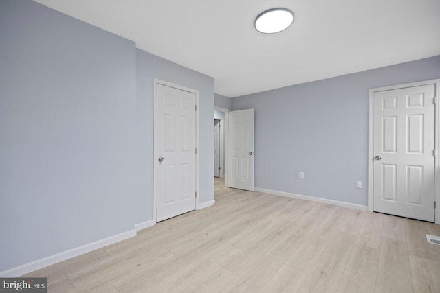 unfurnished bedroom with light wood-type flooring and baseboards