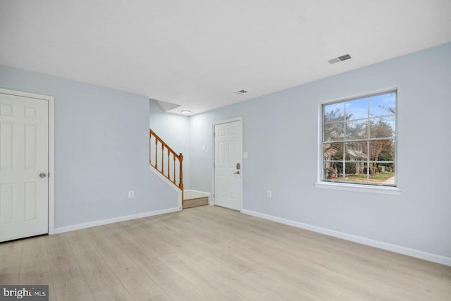 interior space featuring light wood-style floors, baseboards, stairs, and visible vents