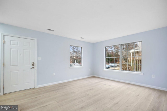 interior space with light wood finished floors, visible vents, and baseboards