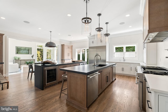 kitchen with a wealth of natural light, a center island with sink, a sink, stainless steel dishwasher, and wine cooler