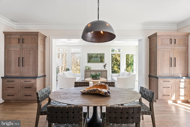 dining room featuring light wood-style floors and crown molding