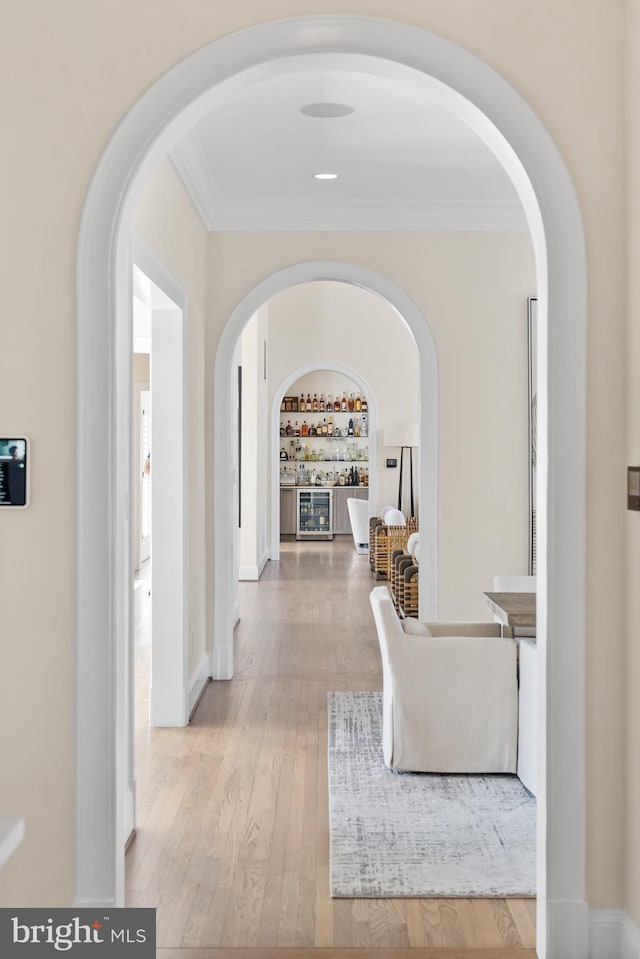 hallway with baseboards, hardwood / wood-style floors, and ornamental molding