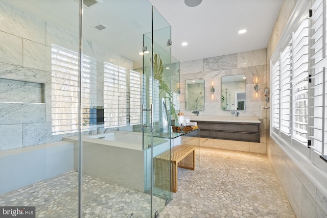 full bath featuring visible vents, tile walls, a stall shower, and a bath