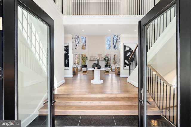 entryway with stairs, french doors, baseboards, and a towering ceiling