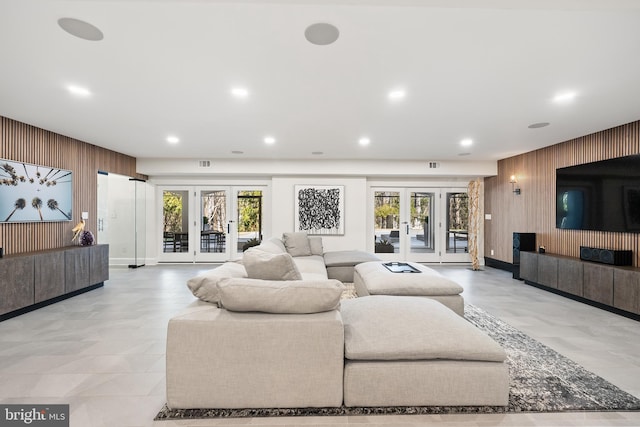 living room featuring recessed lighting, french doors, wood walls, and a healthy amount of sunlight