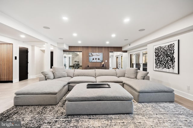 living area with recessed lighting, baseboards, wood finished floors, and wood walls