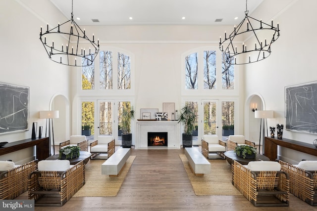 sunroom / solarium with a notable chandelier, french doors, visible vents, and a fireplace with flush hearth