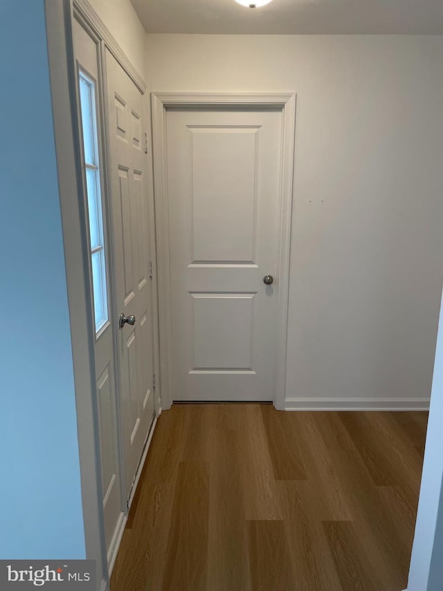 doorway with wood finished floors and baseboards