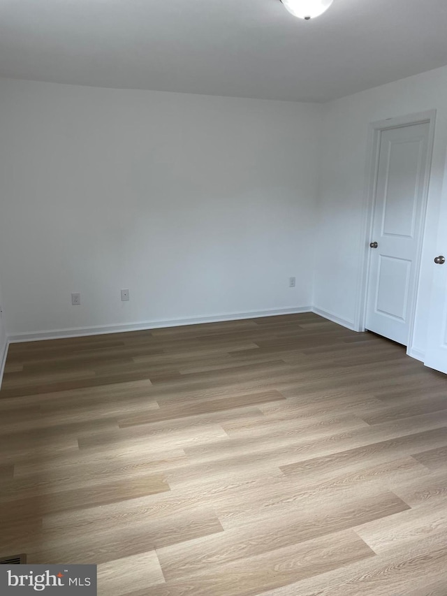 spare room featuring light wood-style floors and baseboards