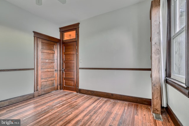 spare room with dark wood-style floors and baseboards