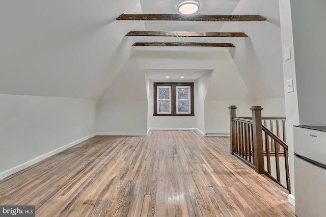 bonus room featuring vaulted ceiling with beams, wood finished floors, and baseboards