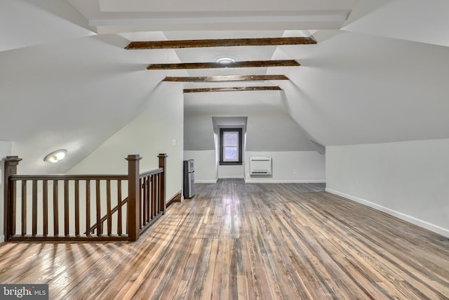 additional living space with vaulted ceiling with beams, wood finished floors, and baseboards