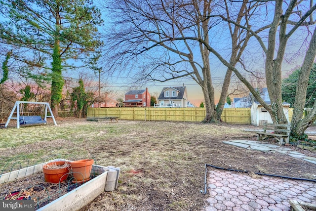 view of yard featuring an outbuilding, a vegetable garden, fence, and a storage unit