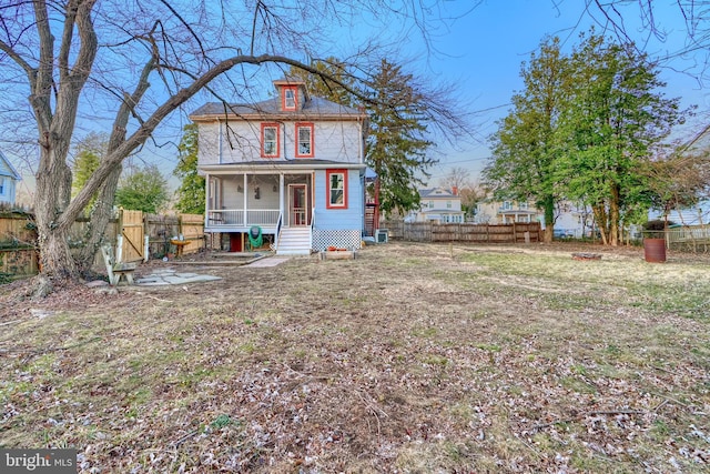 back of house featuring fence and a porch