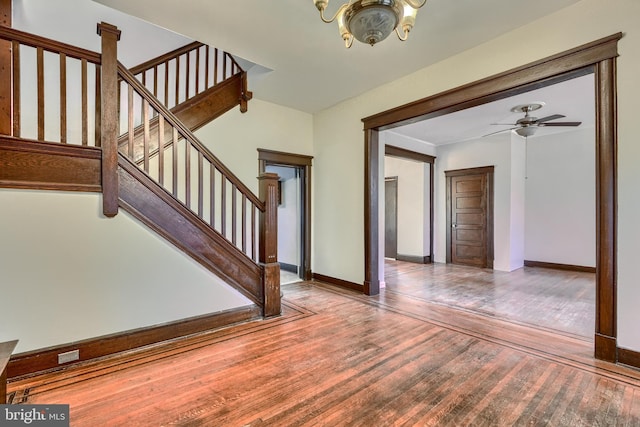 interior space featuring stairs, ceiling fan, wood finished floors, and baseboards