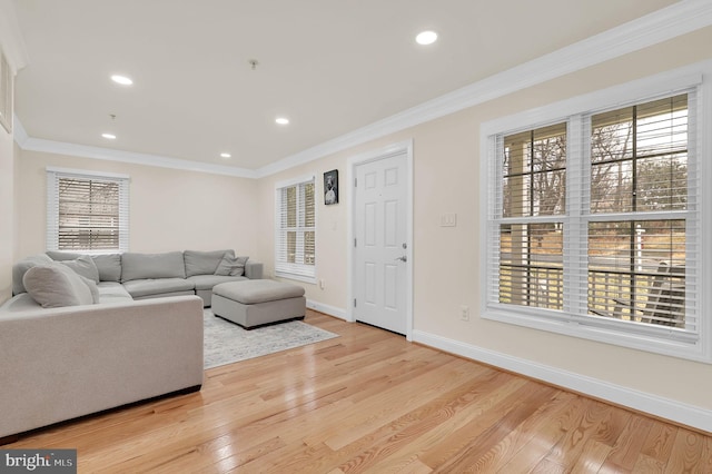 living area with ornamental molding, recessed lighting, light wood-style flooring, and baseboards