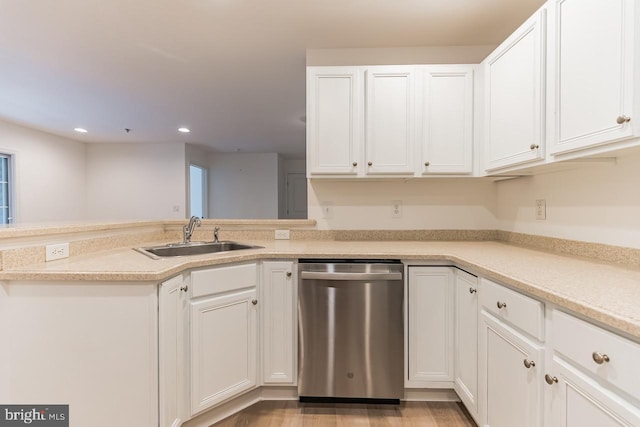 kitchen featuring white cabinets, light countertops, dishwasher, and a sink