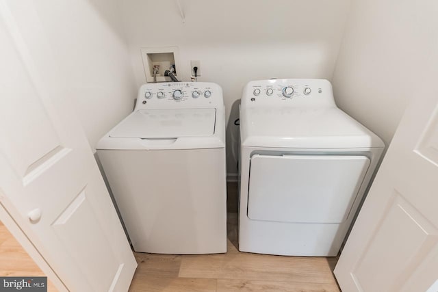 laundry room featuring light wood-type flooring, laundry area, and washing machine and clothes dryer