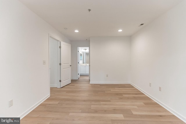 spare room with recessed lighting, visible vents, light wood-style flooring, and baseboards