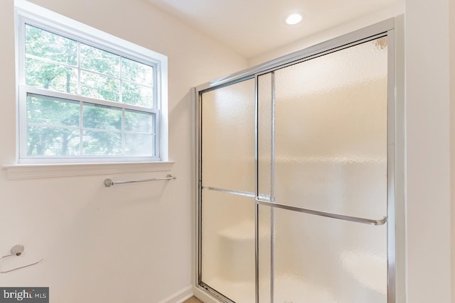 bathroom featuring a shower with door and recessed lighting