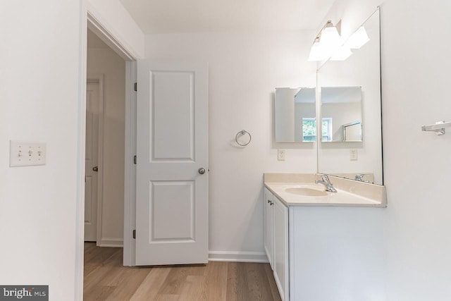 bathroom featuring wood finished floors, vanity, and baseboards