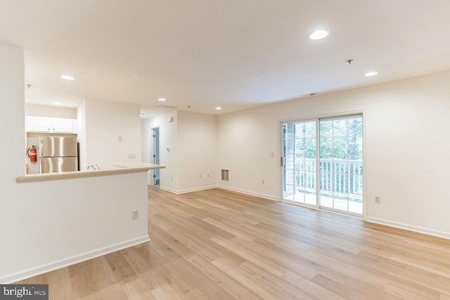 empty room featuring baseboards, light wood finished floors, visible vents, and recessed lighting