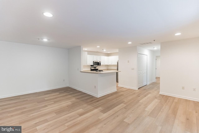 unfurnished living room with light wood finished floors, baseboards, visible vents, and recessed lighting